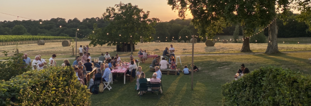 La guinguette du Château Le Grand Verdus à Sadirac, près de Bordeaux, réunit les visiteurs autour des vins du domaine lors d'une soirée d'été au cœur des vignes.